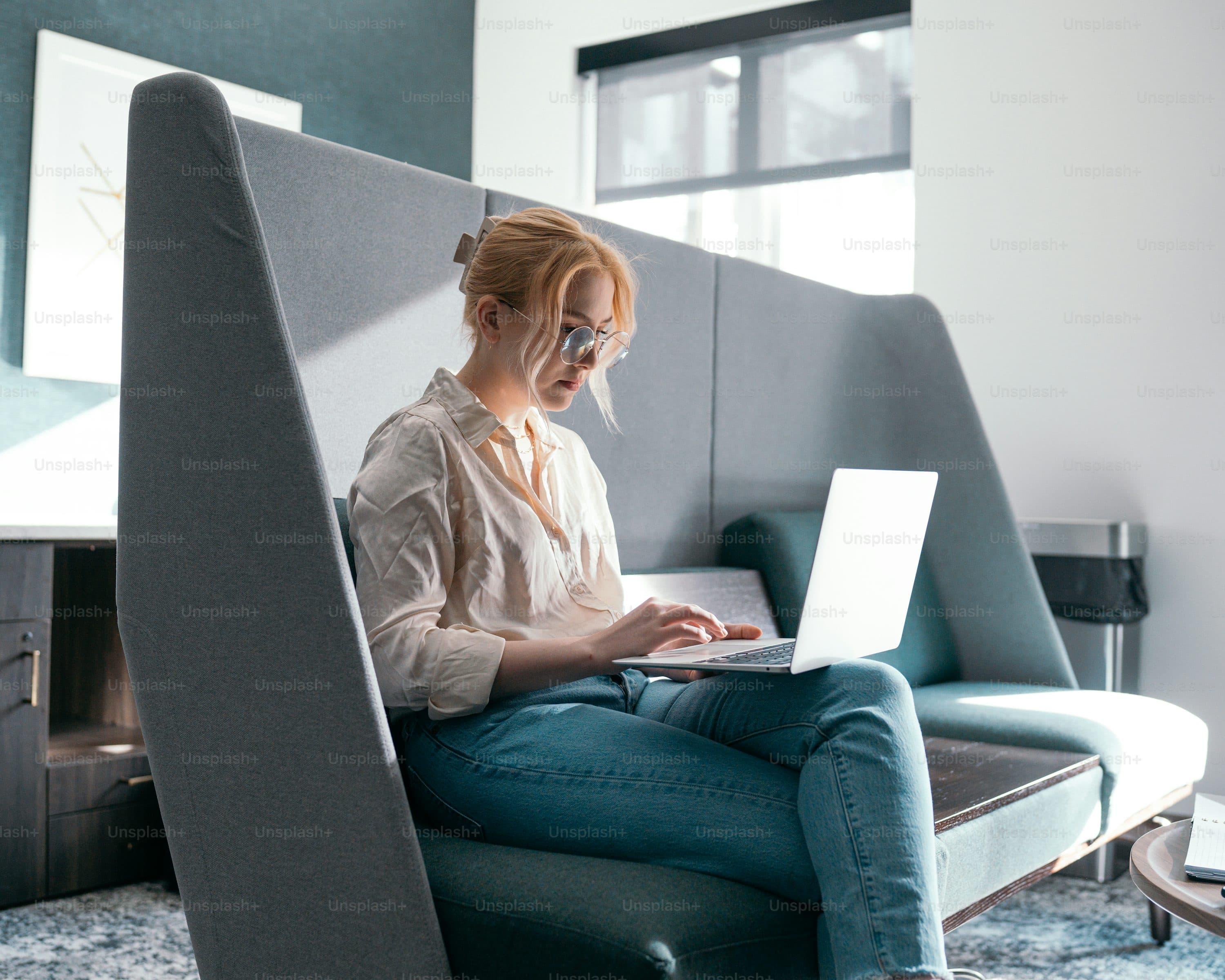 a woman sitting in a chair using a laptop
